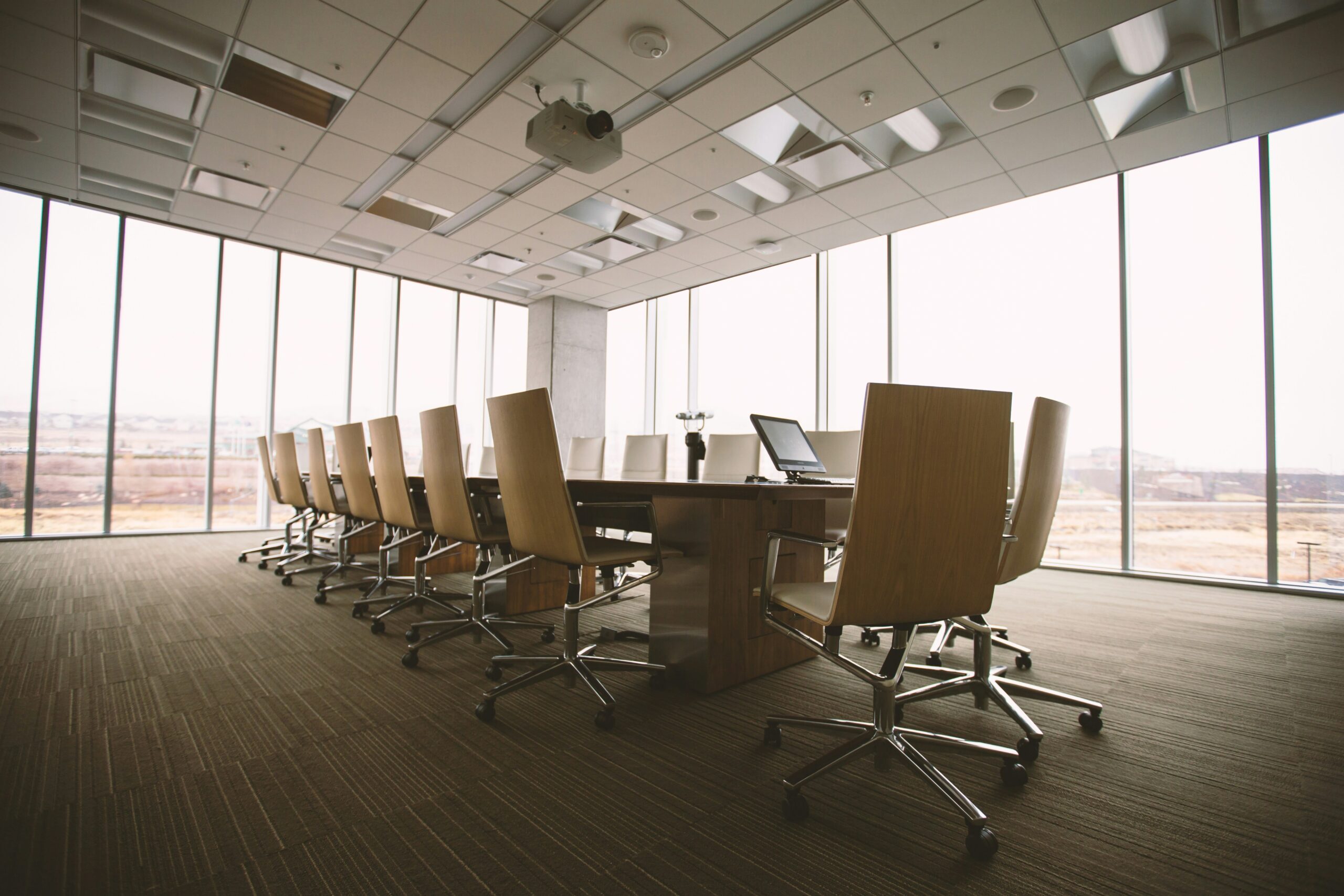 A modern-style business boardroom surrounded by windows, representing commercial space and commercial leases