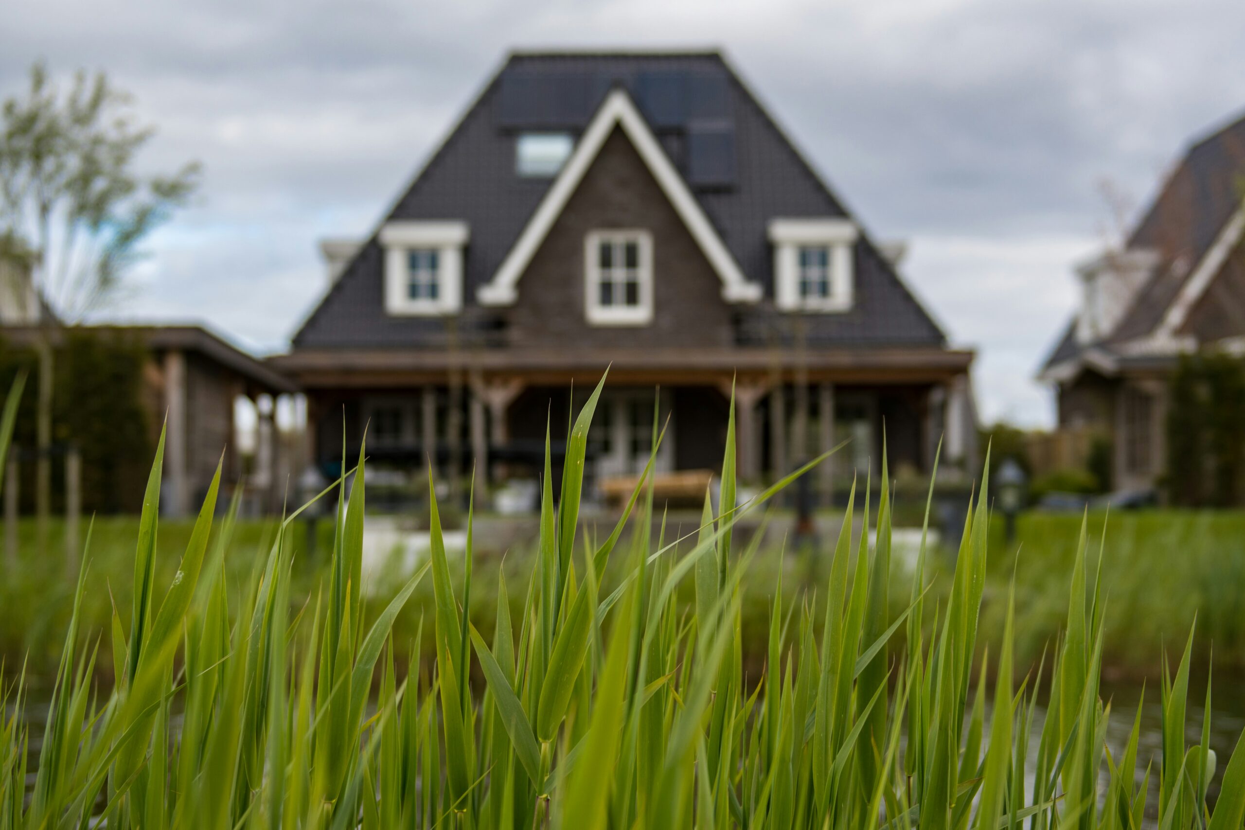 A stately house in the distance as viewed from grass-level, representing property purchases and closing day in BC.