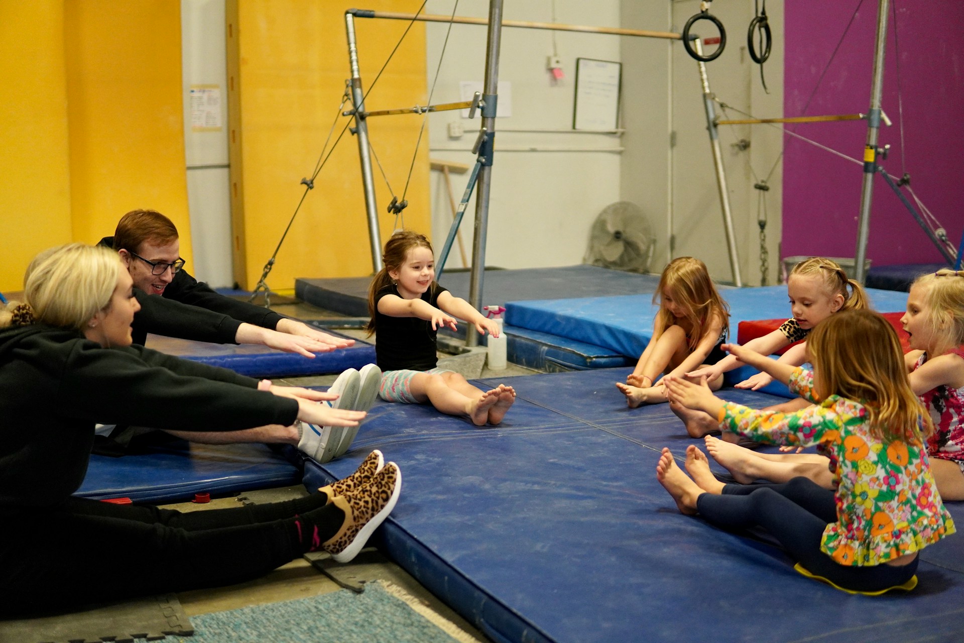 A group of children stretching on gymnastics mats with their instructors, representing a gymnastics business and termination of a franchise agreement in BC