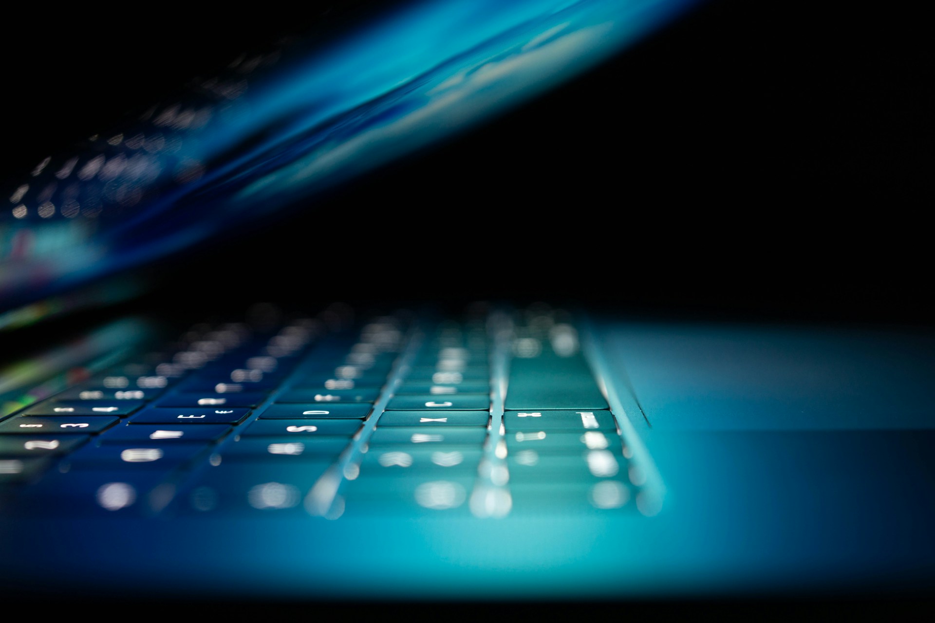 A close-up, side view of a partially open laptop giving off a blue glow, representing privacy law.