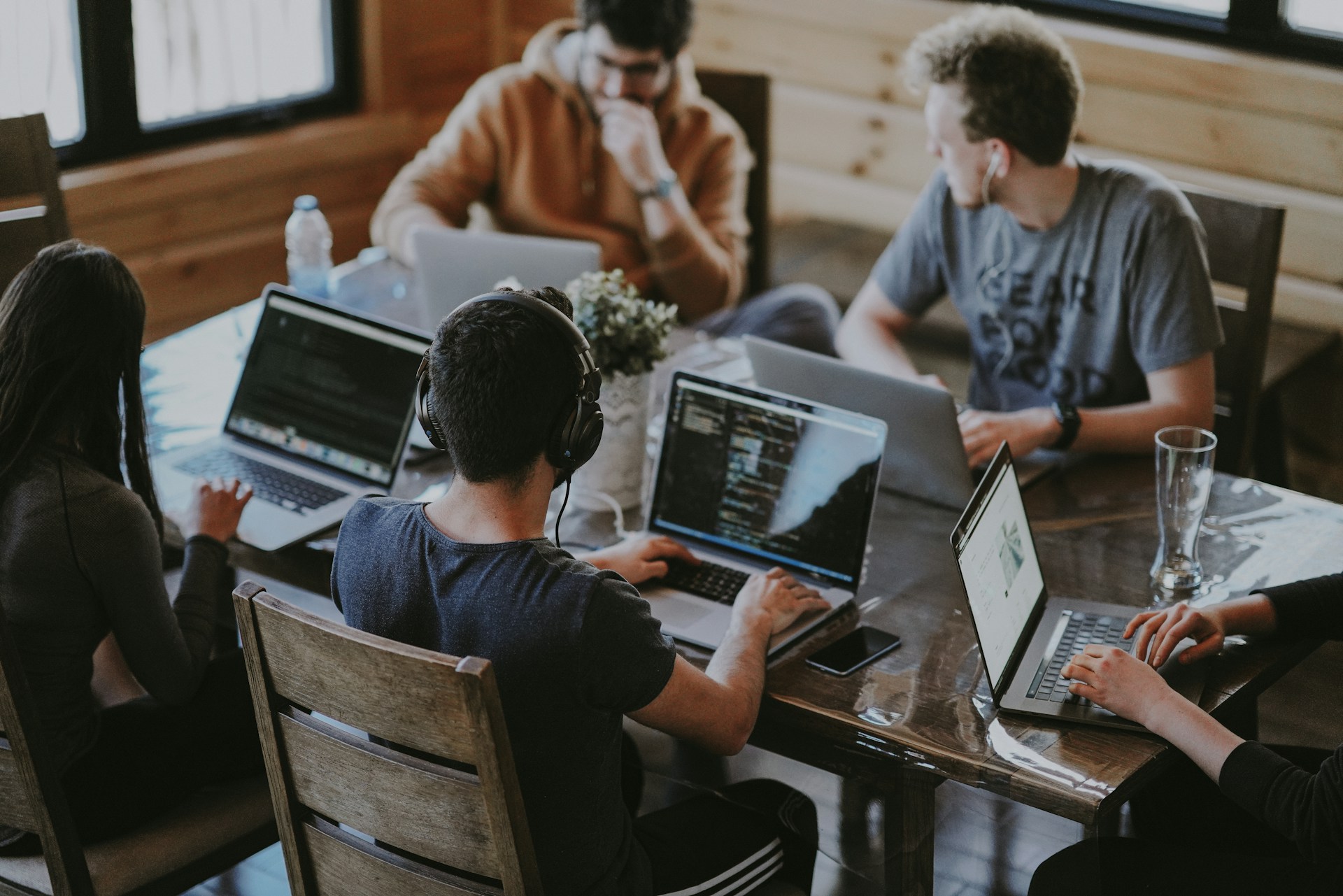 A group of people with laptops meeting around a table, representing liability.