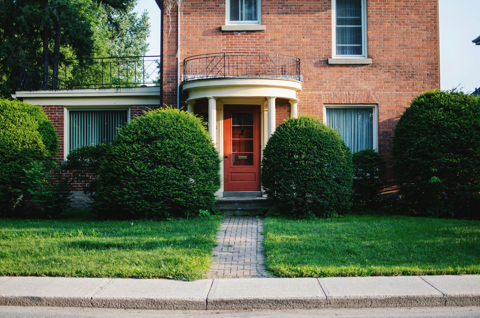 View of a front door of a brick house, surrounded by greenery, representing joint tenancy and family property estate disputes in British Columbia.