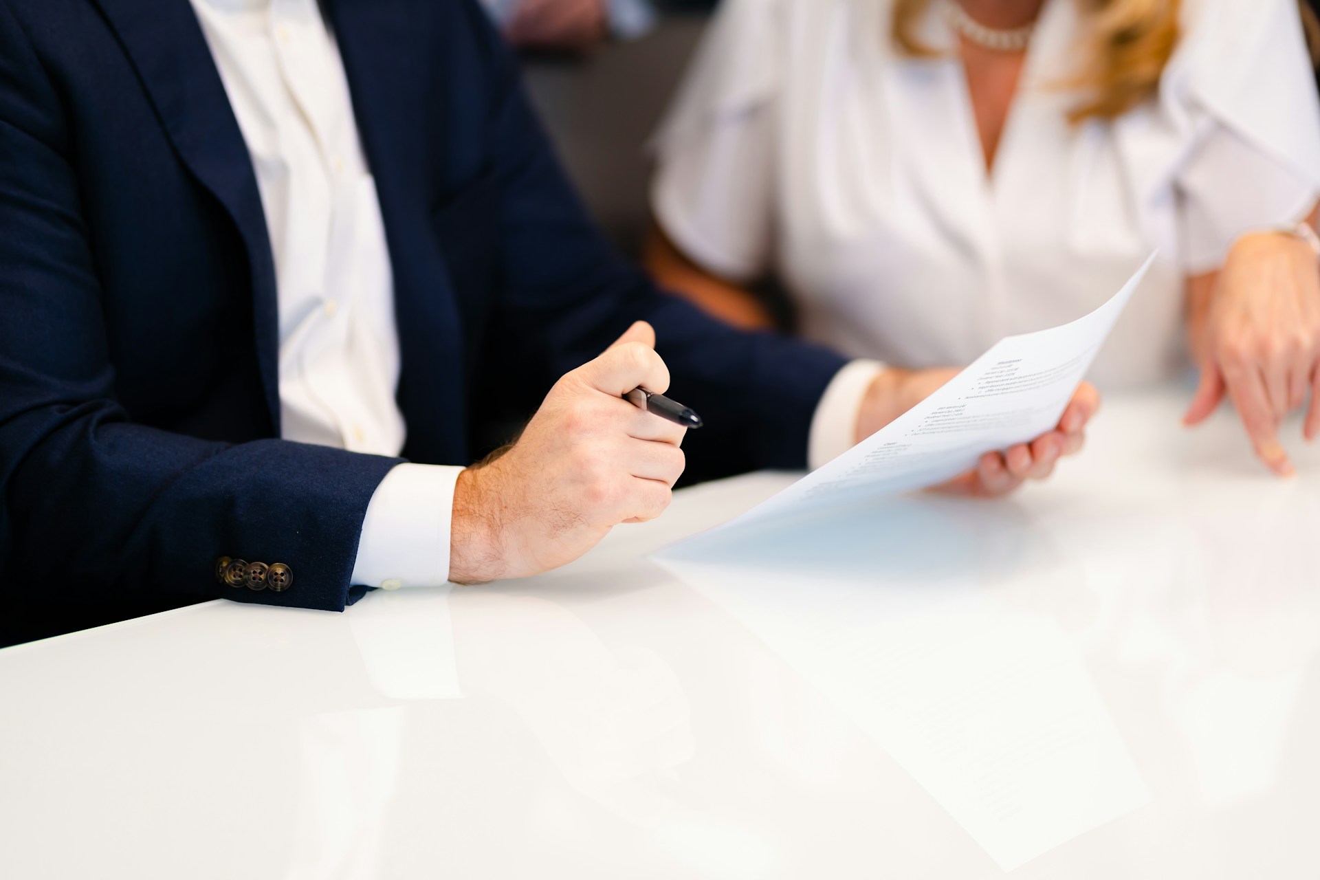 A man and woman, shown from the shoulders down, review documents before signing, representing enduring powers of attorney BC.
